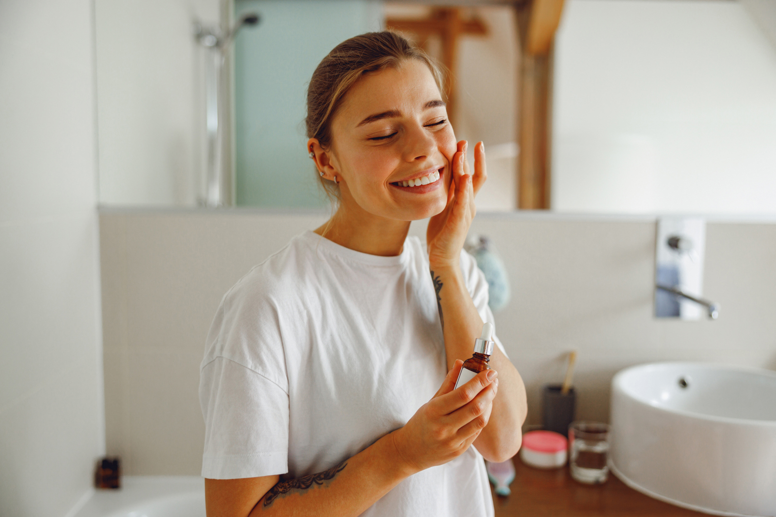 Woman in bathroom applying face care