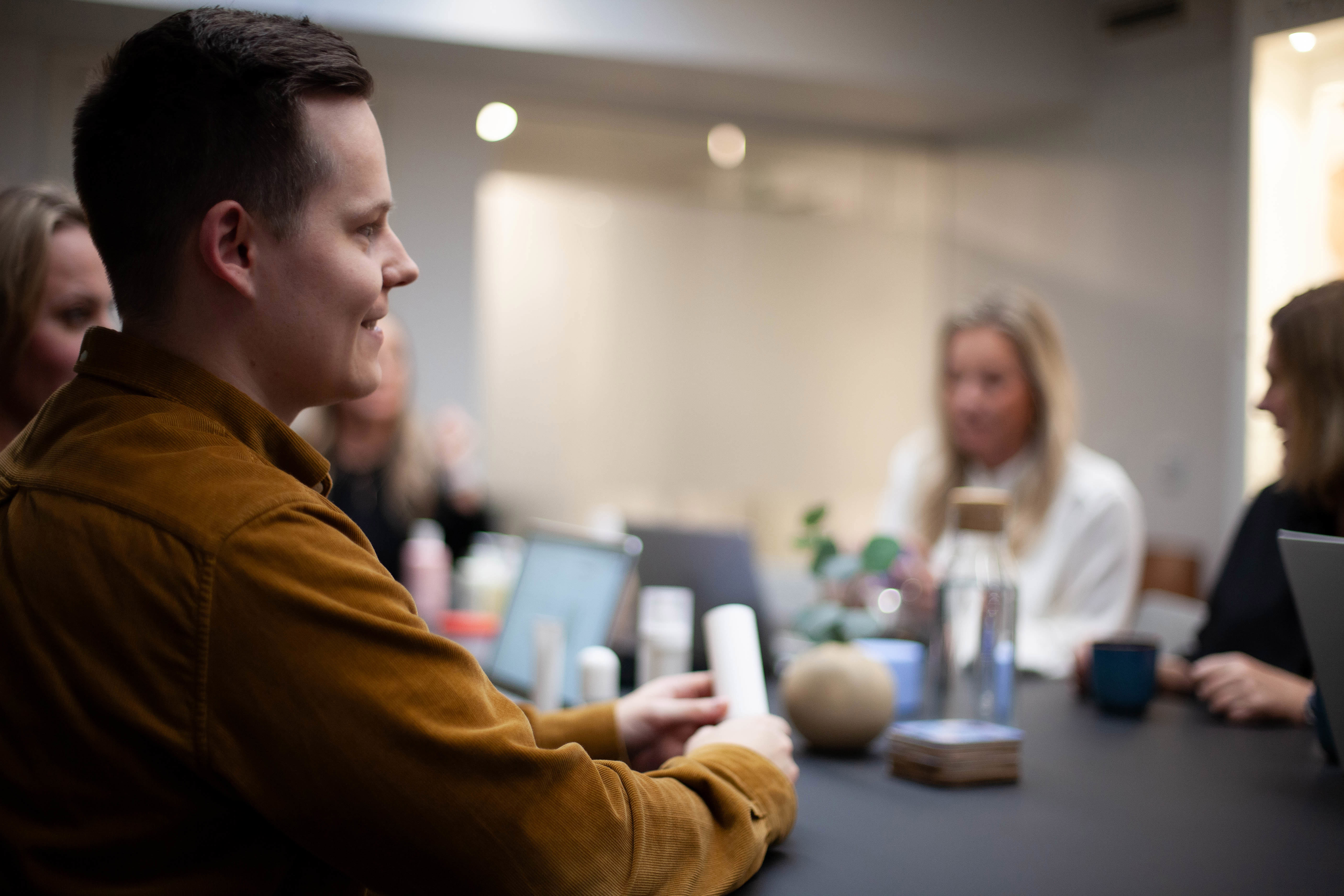 People in a meeting, with various products on the table