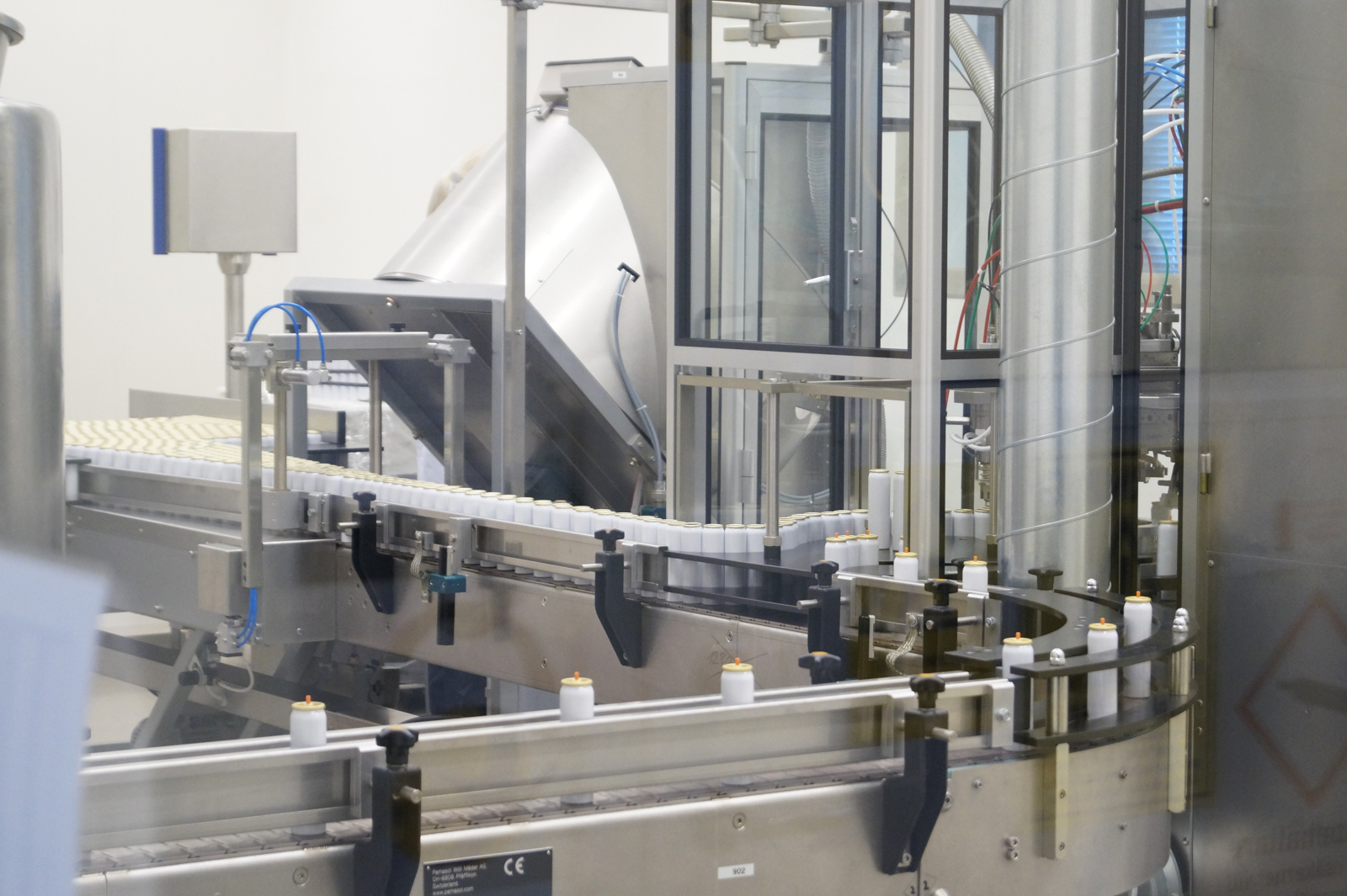 Automated production line with conveyor system and machinery used for filling aerosol containers